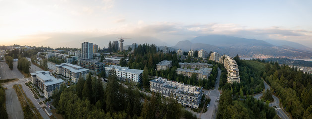 Aerial view of residential buildings on top of Burnaby Mountain during a vibrant sunset. Taken in Greater Vancouver, BC, Canada.