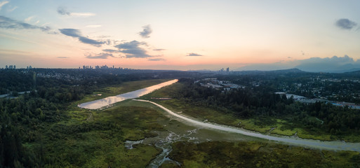 Aerial panoramic view of Burnaby Lake in the modern city during a vibrant summer sunset. Taken in Vancouver, BC, Canada.