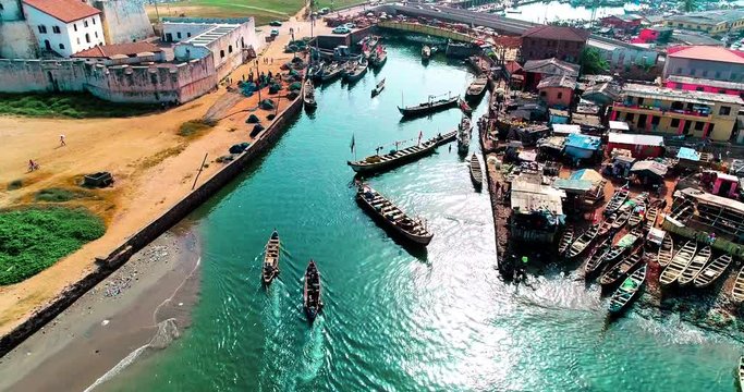 Local docks at Elmina, Ghana. Fishermen from sea entering local port, passing under bridge.