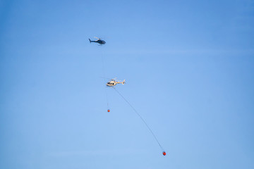 Helicopter fighting BC forest fires during a hot sunny summer day. Taken near Port Alice, Northern Vancouver Island, British Columbia, Canada.