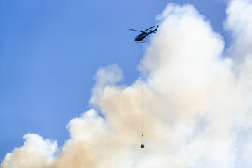 Helicopter fighting BC forest fires during a hot sunny summer day. Taken near Port Alice, Northern Vancouver Island, British Columbia, Canada.