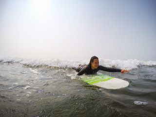 Female beginner surfer is learning how to surf in the Pacific Ocean. Taken in Tofino, Vancouver Island, British Columbia, Canada.