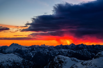 Dramatic dark rain cloud over the Canadian Mountain Landscape during a vibrant sunset. Taken North...
