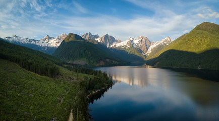 Aerial view of a scenic lake in the Canadian Mountain Landscape during a vibrant summer sunrise. Taken at Jones Lake near Chilliwack and Hope, East of Vancouver, BC, Canada.