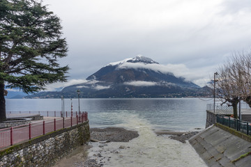 Italy, Varenna, Lake Como, a bench next to a body of water
