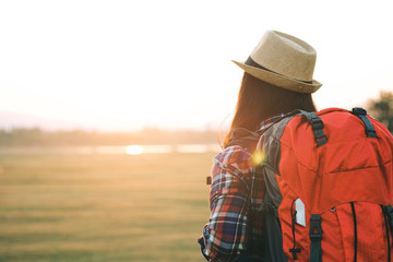 Tourist woman relaxing alone with a large backpack enjoying in lake view. Travel wanderlust lifestyle concept adventure vacations outdoor, Summer holiday and vacation trip