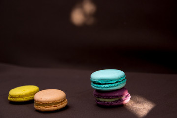 Colourful macarons on a dark background. A popular French dessert.