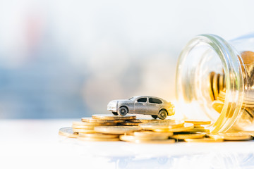 Miniature car model and Financial statement with coins. Finance and car loan, saving money for a car or material design concepts.