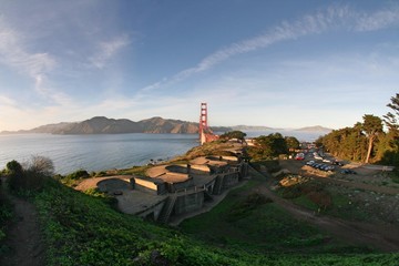 Military base in front of golden gate bridge and ocean during sunset