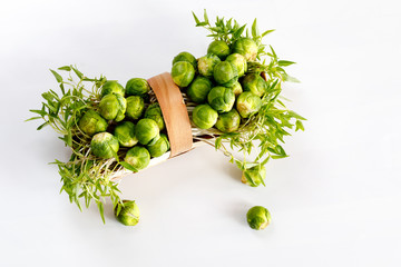 Brussels sprout - vegetable culture. Small fruits in a basket on a wooden background. Soft focus.