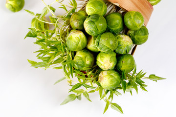 Brussels sprout - vegetable culture. Small fruits in a basket on a wooden background. Soft focus.