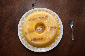 home made vanilla and cinnamon flan over a wooden table