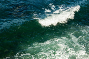 Fototapeta na wymiar A wave crashing on the shoreline in Southern California.