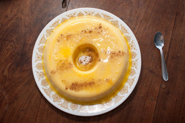 home made vanilla and cinnamon flan over a wooden table