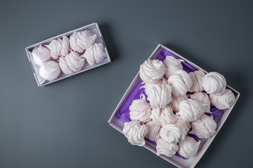 white homemade zefir or marshmallow with powdered sugar on grey background , flatlay , top view with copy space  