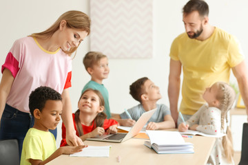 Fototapeta premium Teachers helping children with homework in classroom at school