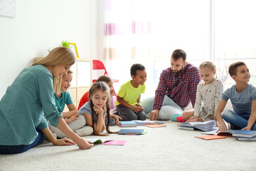 Teachers helping children with homework in classroom at school