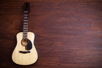Fototapeta na wymiar Acoustic guitar against an old wooden background.