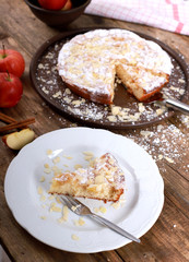 homemade apple pie - a piece of homemade apple pie on a plate with fresh apples and cinnamon sticks on a rustic wooden table