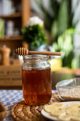 Honey jar with wooden honey dipper on top of it