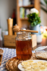 Honey jar with wooden honey dipper on top of it