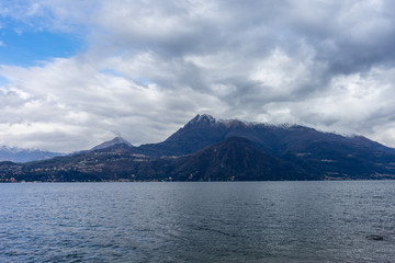 Italy, Varenna, Lake Como, a large body of water with a mountain in the background