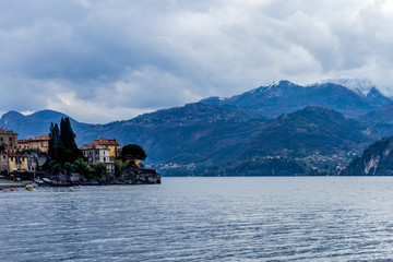 Fototapeta na wymiar Italy, Varenna, Lake Como, a large body of water with a mountain in the background