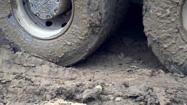 The wheels of a truck that drives through a swamp. Complex construction conditions