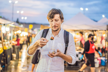 Young man tourist on Walking street Asian food market