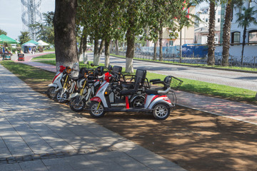 Electric tricycle scooters and Bicycle for rent on Batumi New Boulevard. Seaside promenade in Batumi