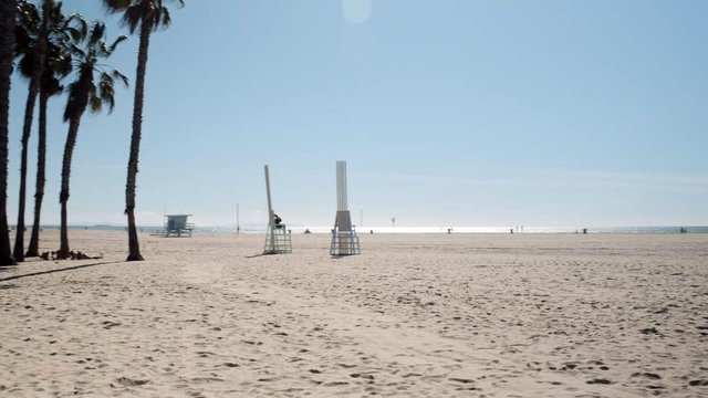 Lifeguard beach tall chairs on the calm serene beach sands of Santa Monica California
(gimbal shot)