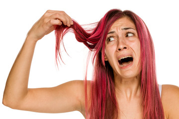 young unhappy woman with pink hair on white background
