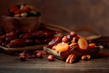 Various dried fruits and nuts in wooden dish.