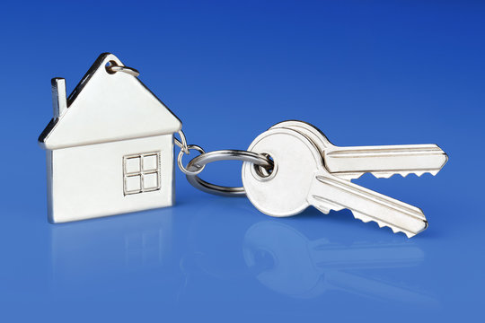 House Keys With House Shaped Keychain On Blue Background