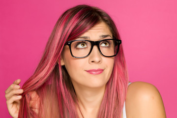 young worried woman with pink hair on a pink background
