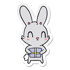 sticker of a cute cartoon rabbit with present