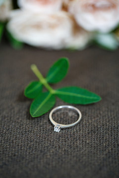 Gold wedding rings on a green petal