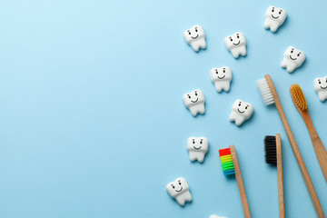 Healthy white teeth are smiling on blue background with toothbrush. Copy space for text.