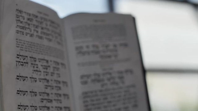 jewish man holding a bible dolly shot from bible close up