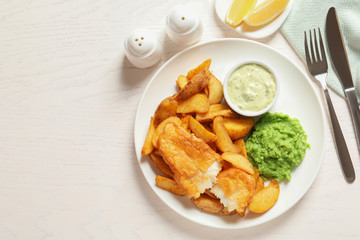 British Traditional Fish and potato chips on wooden background, flat lay. Space for text