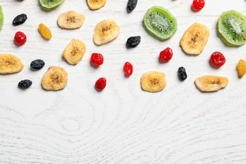 Flat lay composition with different dried fruits on wooden background, space for text. Healthy lifestyle
