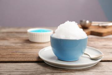 Bowl of tasty snow ice cream on wooden table. Space for text
