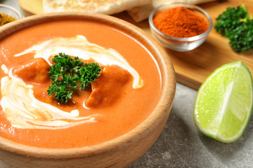 Bowl of delicious butter chicken on served table, closeup. Traditional indian Murgh Makhani