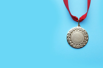 Gold medal with space for design on color background, top view. Victory concept