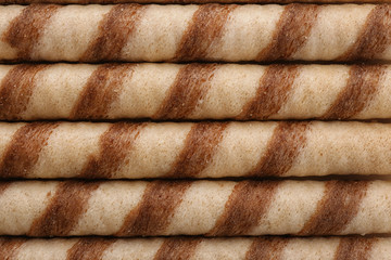 Tasty wafer roll sticks as background, top view. Crispy food