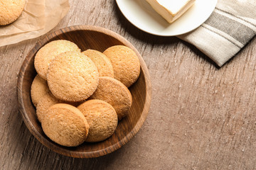 Bowl with Danish butter cookies on wooden background, top view. Space for text