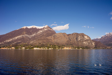 Italy, Bellagio, Lake Como, SCENIC VIEW OF SNOWCAPPED MOUNTAINS AGAINST BLUE SKY
