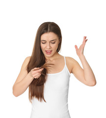 Emotional woman with damaged hair on white background. Split ends