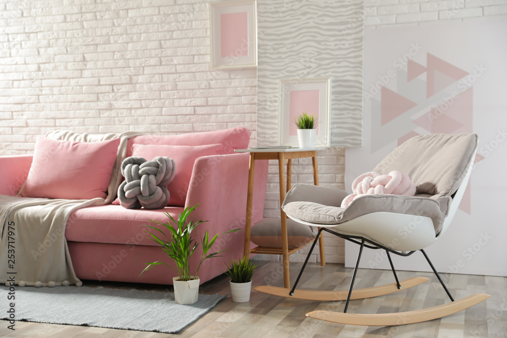 Sticker Stylish living room interior with sofa and rocking armchair near brick wall