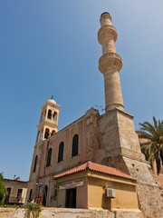 Orthodox church and muslim mosque side by side at the old venetian harbor, city of Chania, Crete island, Greece